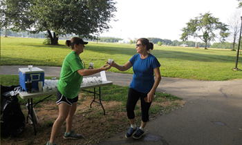 Woman giving water to runner